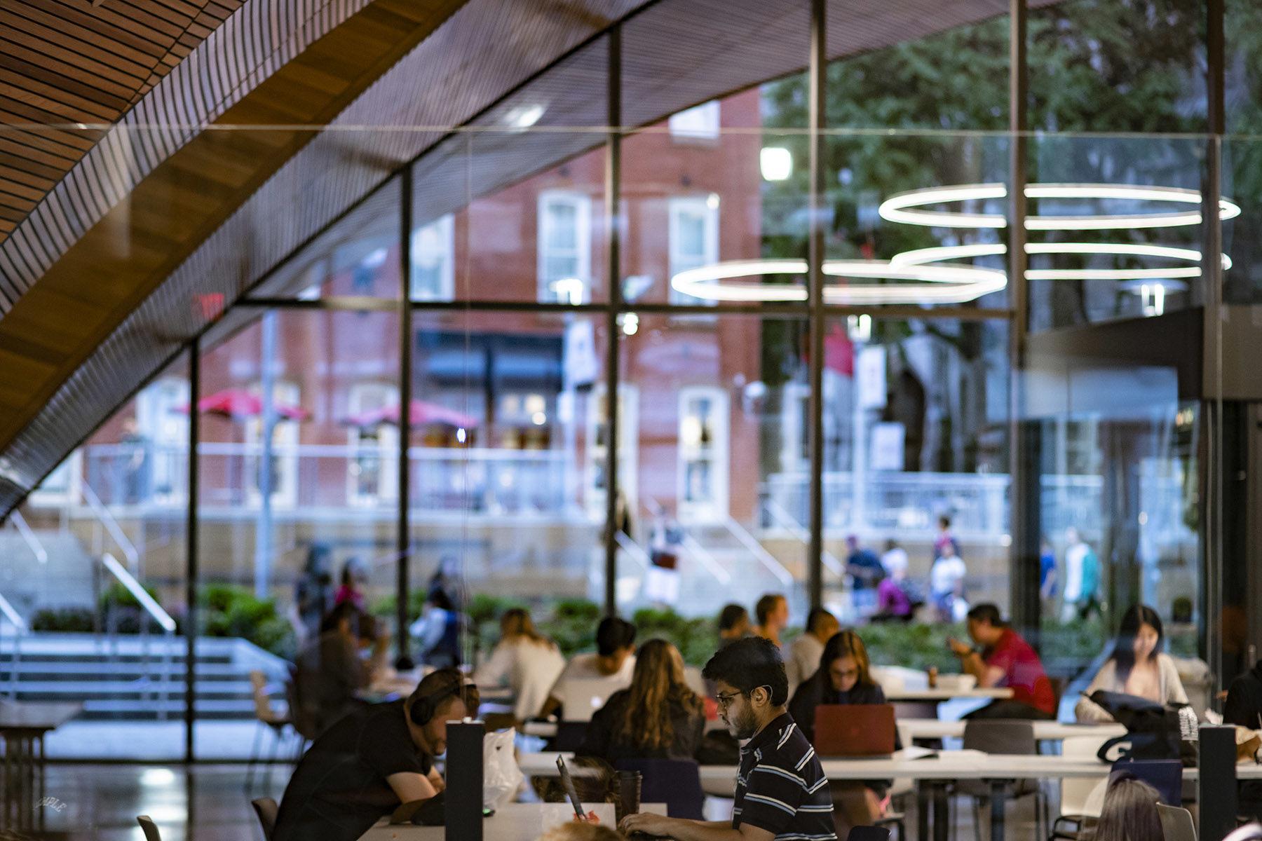 students studying in 查尔斯·库 with windows facing out to Liacouras Walk